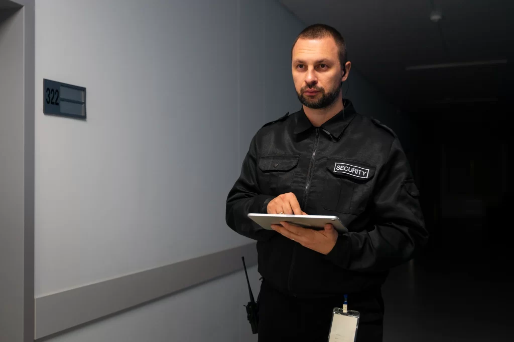 AMC Security Guard Services Dubai - Security guard conducting building inspection and monitoring services in Dubai commercial property
